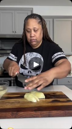 a woman cutting onions on top of a wooden cutting board