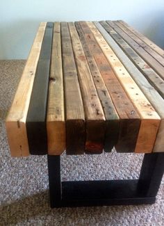 a wooden table made out of several different types of wood planks on the floor