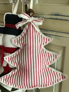 a red and white christmas tree ornament hanging from a door