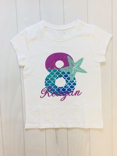 a white t - shirt with the number 8 and starfish in purple, blue and green