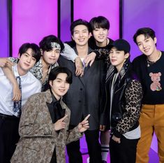 the group of young men are posing for a photo together in front of purple background