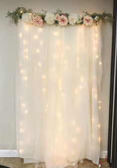 a white curtain with flowers and lights on it