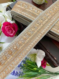 the cross has been decorated with gold sequins and is next to some flowers