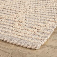 a close up of a rug on the ground with wood flooring in the background