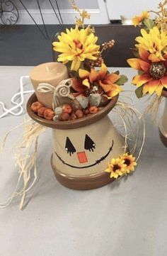 two vases with sunflowers and other decorations on a table