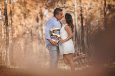 a man and woman kissing in the woods with an i love 3 sign on it