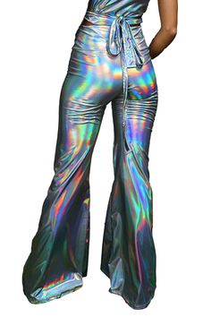 Step into the future with our mesmerizing holographic silver bell bottoms, a dazzling fusion of retro charm and futuristic allure. These eye-catching disco flares are crafted to captivate, boasting an otherworldly shine that transforms every movement into a hypnotic show. Designed with both style and comfort in mind, these pants feature a figure-hugging fit that seamlessly transitions into a dramatic flare, flattering all body shapes and sizes. More than just a piece of clothing, these pants are Rainy Festival Outfit, Neon Rave Outfits, Beach Festival Outfit, Winter Rave Outfits, Neon Rave, Cyberpunk Clothes, Burlesque Costumes, Summer Festival Outfit, Burning Man Outfits