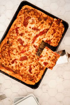 a square pizza sitting on top of a pan covered in cheese and pepperoni toppings