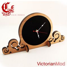 a wooden clock with an intricate design on the face and hands, sitting in front of a white background