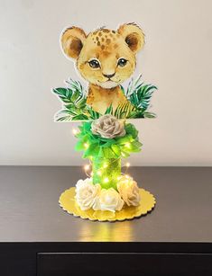 an animal figurine sitting on top of a table with flowers and lights around it