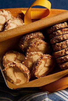 a wooden tray filled with pastries next to an orange ribbon