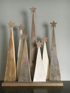 three wooden christmas trees with stars on them