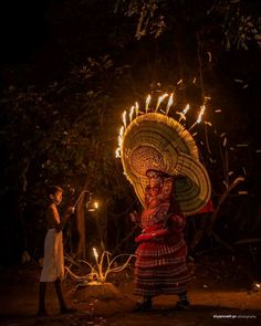 a woman holding a lit up fan in her hand and another person standing next to her