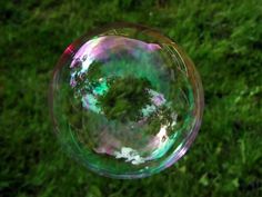 a soap bubble floating in the air on top of green grass