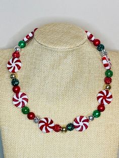 a necklace with candy canes and christmas decorations on the beaded stranding around it