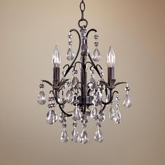 a chandelier with crystal drops hanging from it's center point, on a beige background