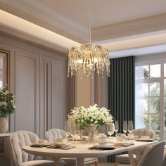 an elegant dining room with chandelier and white flowers in vases on the table