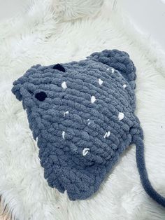 a blue knitted object laying on top of a white furnishing covered floor