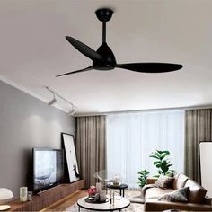 a living room with a ceiling fan in the middle of it and a tv on