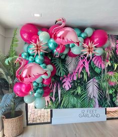 flamingos and other tropical plants are on display at the entrance to a building with a sign that reads 12 feet garland