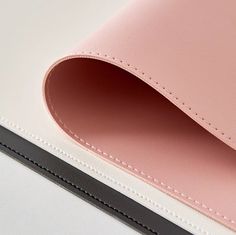 the inside of a pink and white leather case with black trim on an ipad pro