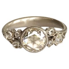 an image of a ring with diamonds on it's sides and the center stone surrounded by smaller stones