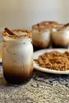 there are two desserts in jars on the table with cinnamon sticks sticking out of them