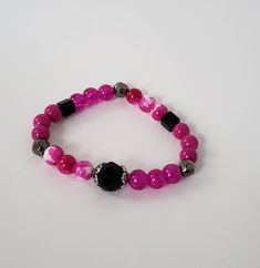 Add a little fun with this bright pink and black bracelet with elastic band. Handmade in the U.S. by Cogan Couture. Pink Flexible Beaded Bracelets For Gifts, Pink Beaded Bracelets For Gift, Pink Jewelry With Adjustable Black Beads, Adjustable Pink Stretch Bracelet, Flexible Pink Beaded Bracelets, Flexible Pink Beaded Bracelet, Pink Adjustable Stretch Bracelet As Gift, Handmade Flexible Pink Bracelets, Adjustable Pink Stretch Bracelet Gift