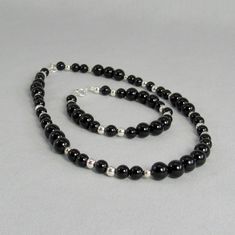 Highly polished black onyx that will add sleek sophistication to your everyday style. This natural stone and sterling silver necklace has 6mm and 8mm black gemstone beads with 4mm and 5mm sterling silver beads. It has a sterling spring ring clasp and is available in two lengths. Choose 16 inch or 20 inch -- or maybe you should get both to create a layered statement. This necklace and all KBeadsIt jewelry ships free with USPS first class domestic package service. The bracelet and earrings are sol Elegant Black Sterling Silver Beaded Necklaces, Black Sterling Silver Jewelry With 8mm Beads, Elegant Obsidian Beads Jewelry 8mm, Black Sterling Silver Beaded Necklace For Gift, Necklace Elegant, Buy Bead, Black Polish, Natural Stone Jewelry, Everyday Necklace