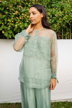 Green silk organza 3D hand embroidered shirt with floral motifs. Comes with an inner.
Components:2
Pattern:Embroidered
Type of Work:Hand Embroidered
Neckline:Round
Sleeve Type:Puffed sleeves
Fabric:Shirt: 100% Silk Organza, Inner: Viscose Tabby
Color:Green
Other Details:
Note: The pant worn by model is not for sale.
Occasion:Party,Work - Aza Fashions Hand Embroidered Shirt, 3d Hand, Floral Embroidered Top, Green Hand, Embroidered Neckline, Silk Organza, Top For Women, Green Shirt, Green Silk