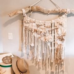 a hat and other items are displayed on a shelf next to a driftwood wall hanging