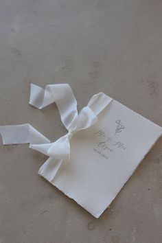 a piece of white paper with a bow on it