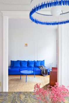 a living room with blue couches and chandelier