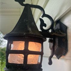 an old fashioned light hanging on the side of a house's exterior wall or door