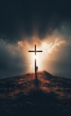 a person standing on top of a hill under a cross