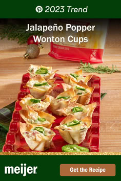 a red tray filled with wonton cups on top of a wooden table next to a bag of chips