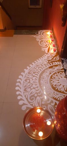 candles are lit on the floor in front of an intricately designed design