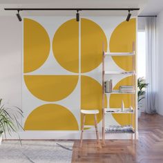 a yellow and white wall mural with circles on it in an office space next to a ladder