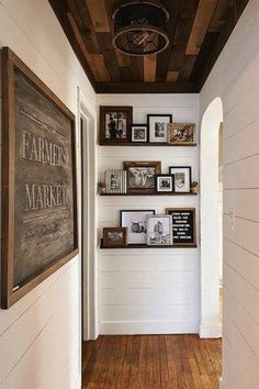 the hallway is lined with framed pictures and wooden shelves