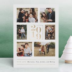 a white christmas card with photos and the number twenty nine on it next to a small tree