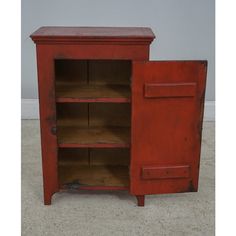 an old red cabinet with two open doors