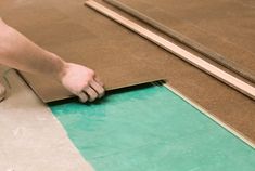 a person laying down some brown paper on the floor