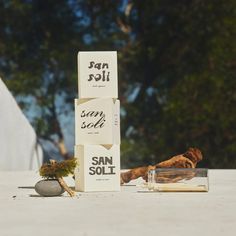 some sort of box sitting on the ground next to an empty glass bottle and rocks