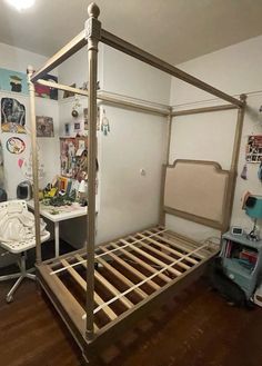 a metal bed frame sitting on top of a hard wood floor next to a white wall