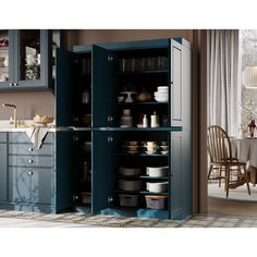 a kitchen with blue cupboards and white counter tops in front of a dining room table