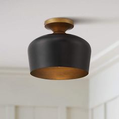 a black and gold light fixture hangs from the ceiling in a room with white walls