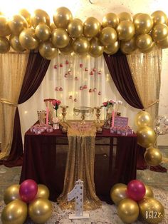 the table is set up with gold and pink balloons