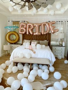 a bedroom decorated with balloons that spell out the word bride and an image of a bed