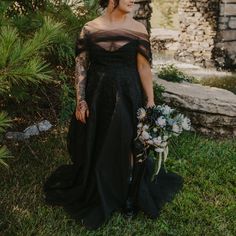 a woman in a black dress holding a bouquet