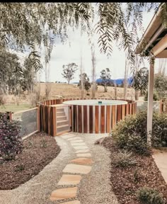 an outdoor hot tub surrounded by trees and gravel